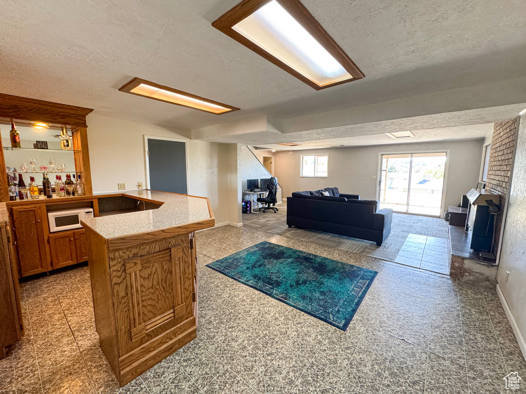 Living room featuring a textured ceiling and bar area