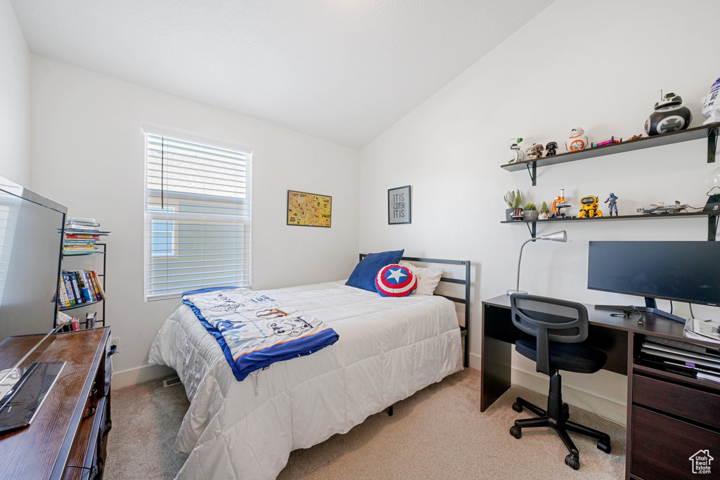 Carpeted bedroom featuring vaulted ceiling