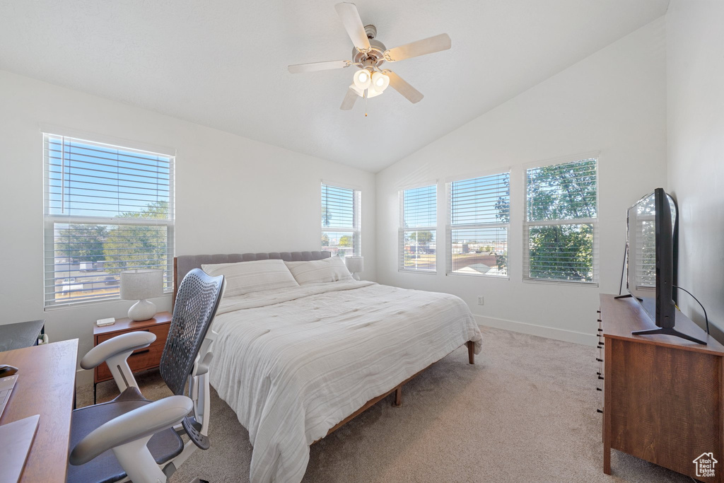 Carpeted bedroom with lofted ceiling and ceiling fan