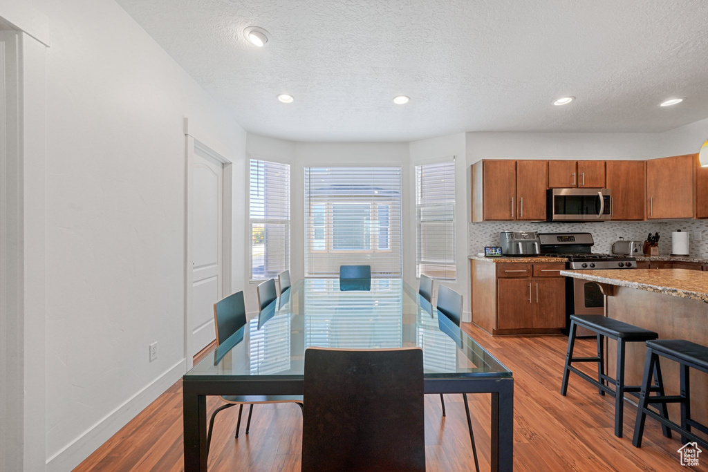 Dining space featuring light hardwood / wood-style floors and a textured ceiling