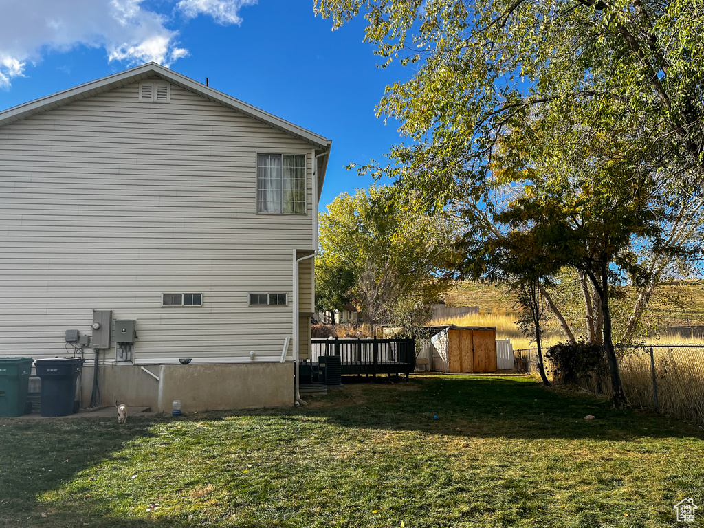 View of side of property featuring a shed and a lawn