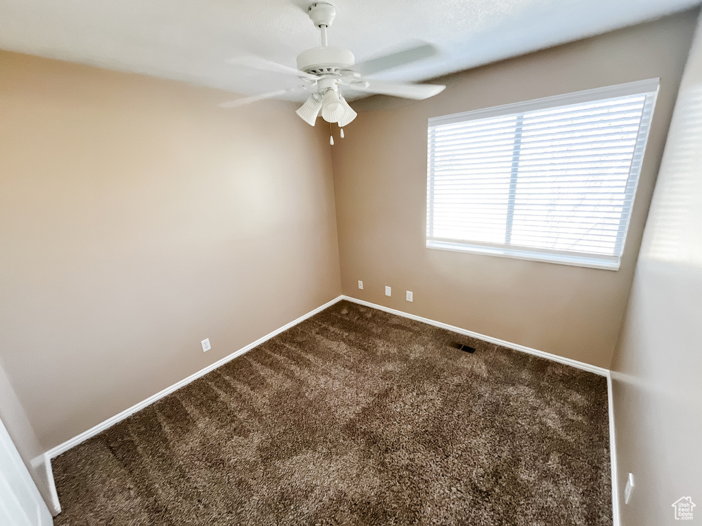 Empty room with carpet flooring and ceiling fan