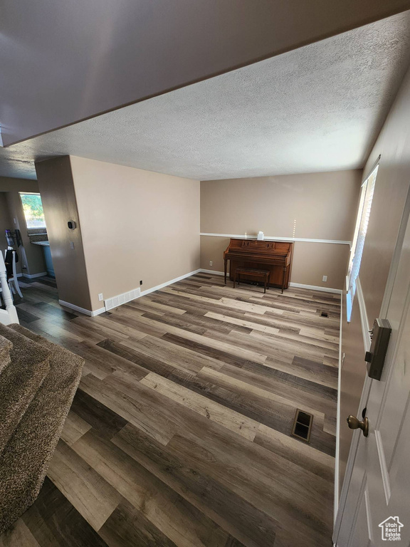 Empty room featuring wood-type flooring and a textured ceiling