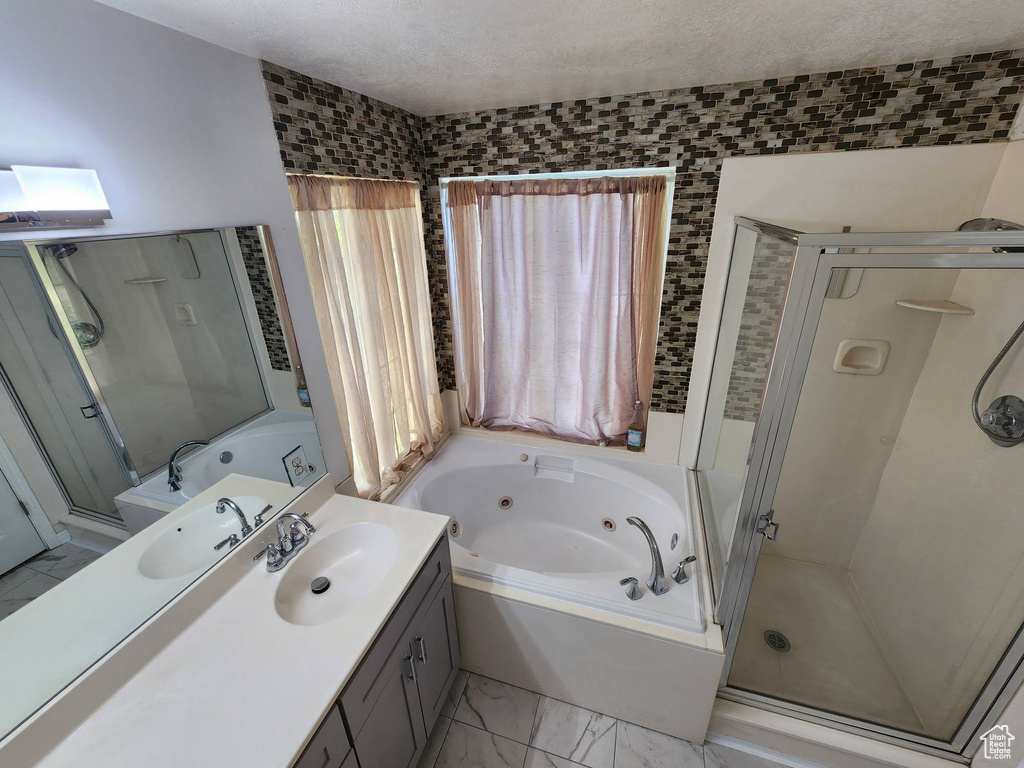 Bathroom with vanity, plus walk in shower, and a textured ceiling