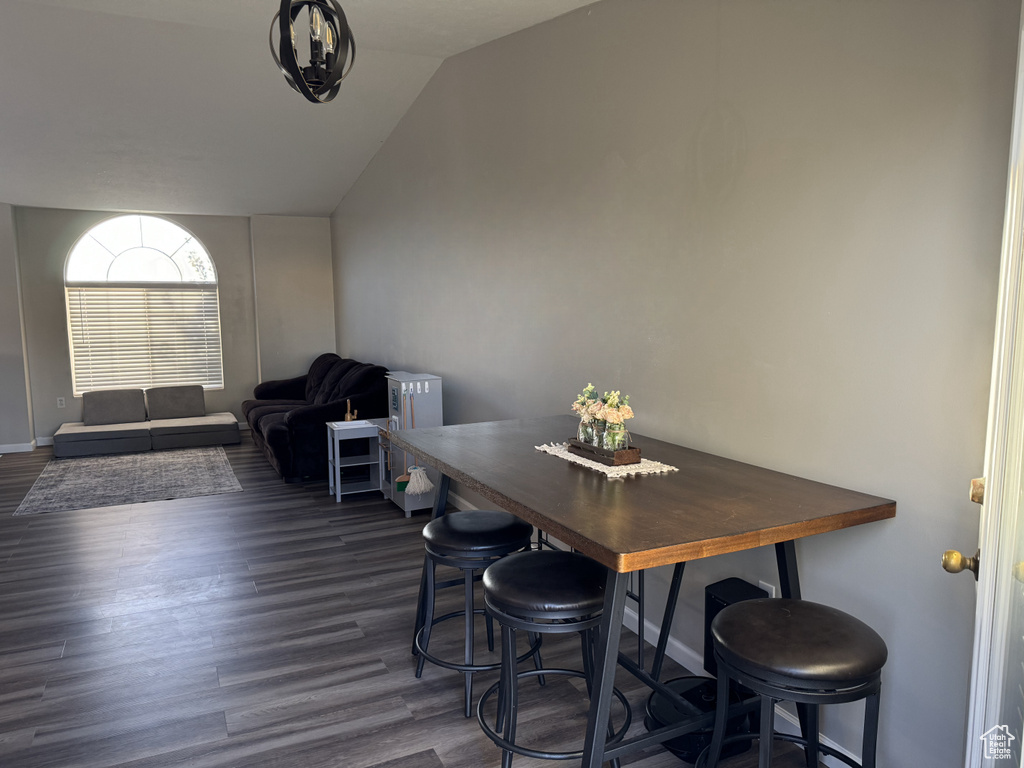 Dining space featuring vaulted ceiling and dark hardwood / wood-style flooring