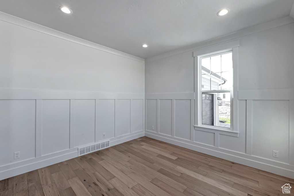 Spare room with light hardwood / wood-style flooring and ornamental molding