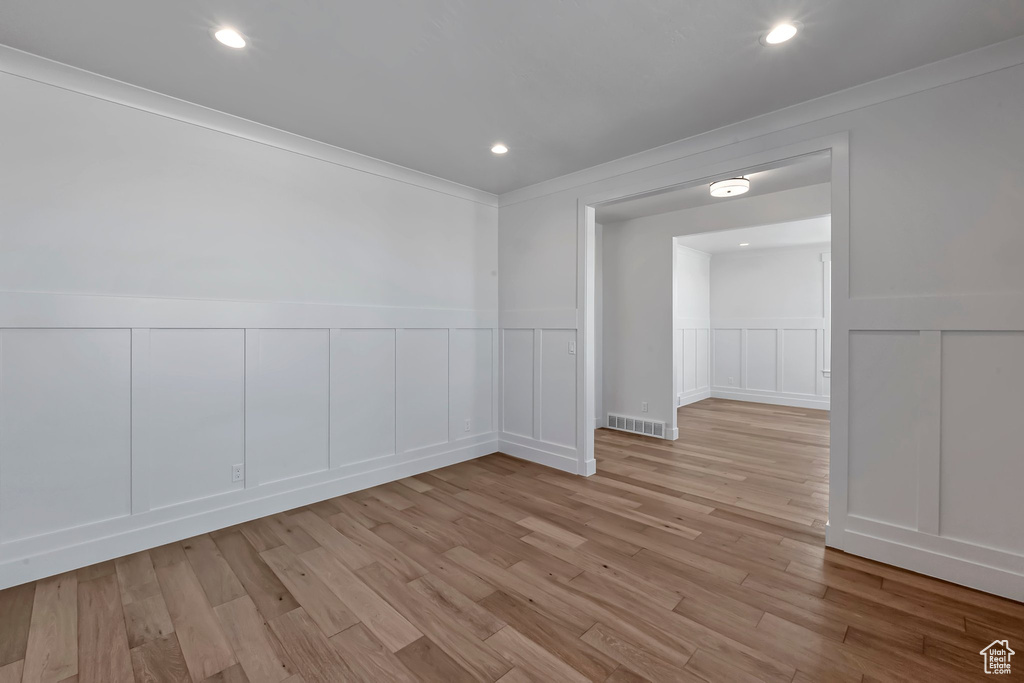 Spare room with light hardwood / wood-style floors and ornamental molding