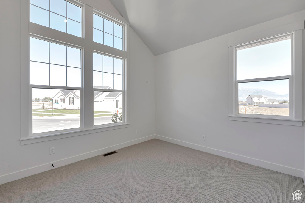 Unfurnished room with light colored carpet and a wealth of natural light