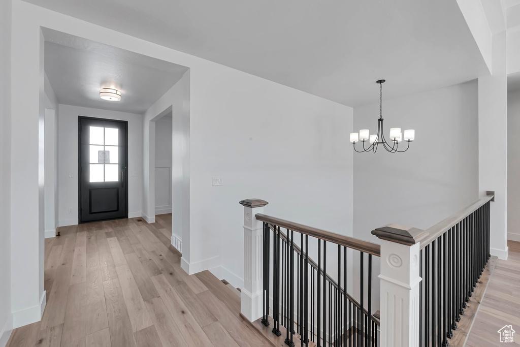 Foyer entrance featuring light hardwood / wood-style flooring and an inviting chandelier