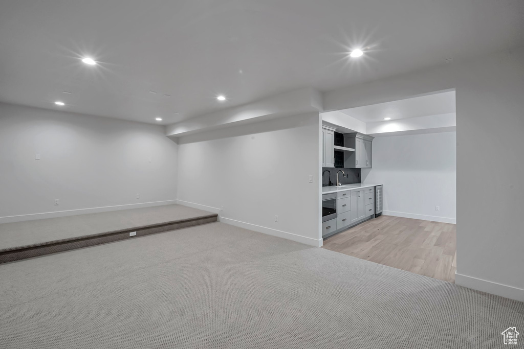 Basement with light wood-type flooring and sink