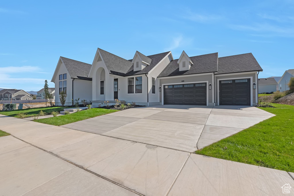 View of front of home with a garage and a front yard