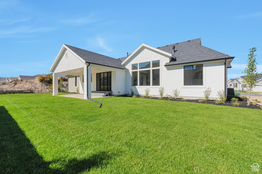 Back of house with a patio and a yard