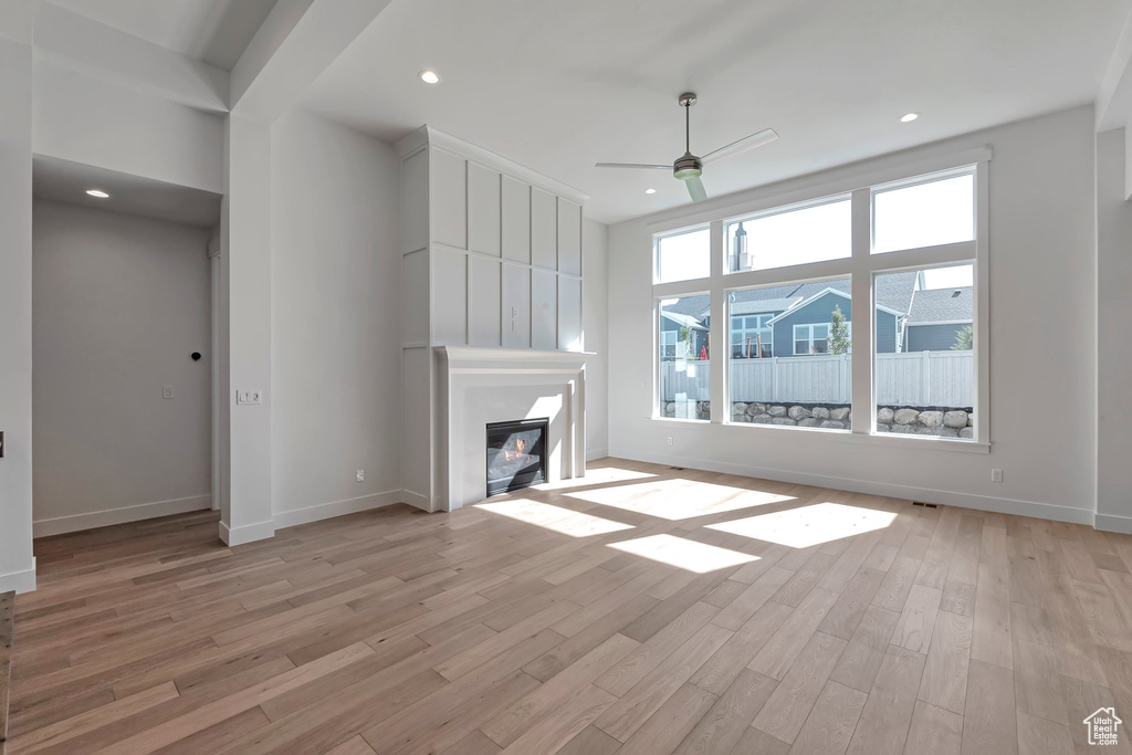 Unfurnished living room featuring ceiling fan and light hardwood / wood-style floors