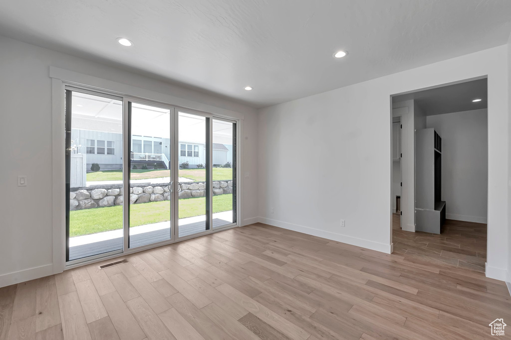 Unfurnished room featuring light wood-type flooring and a healthy amount of sunlight