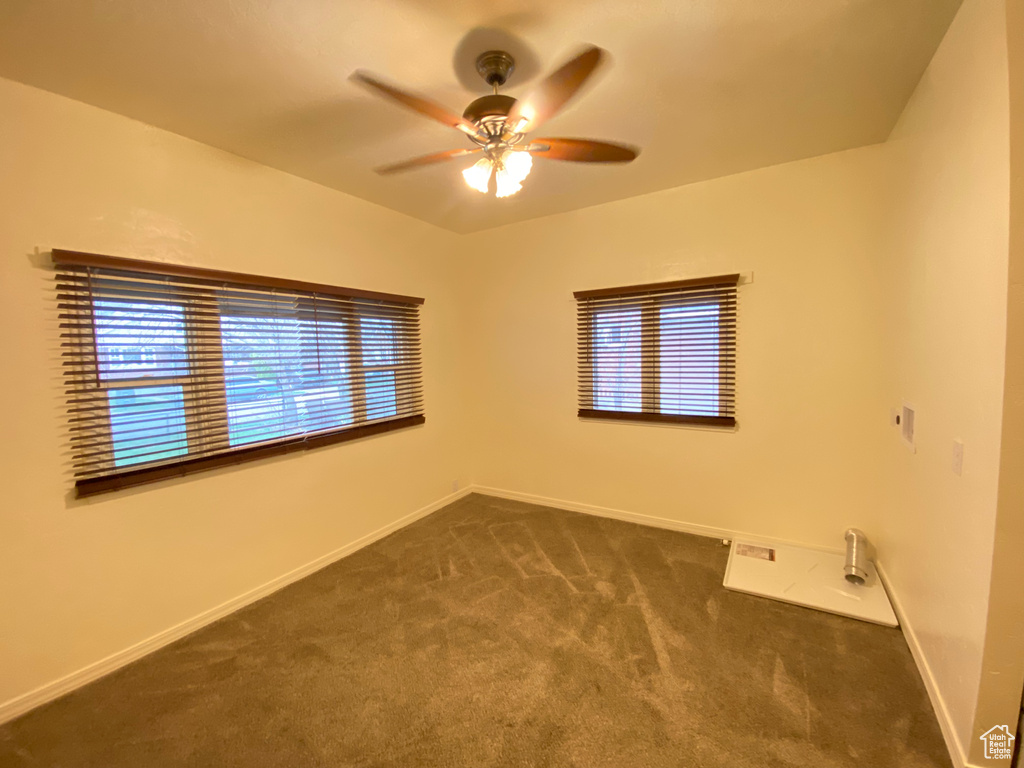 Carpeted empty room featuring ceiling fan and a healthy amount of sunlight