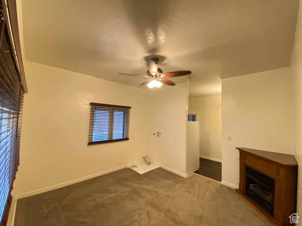 Interior space featuring ceiling fan and dark carpet