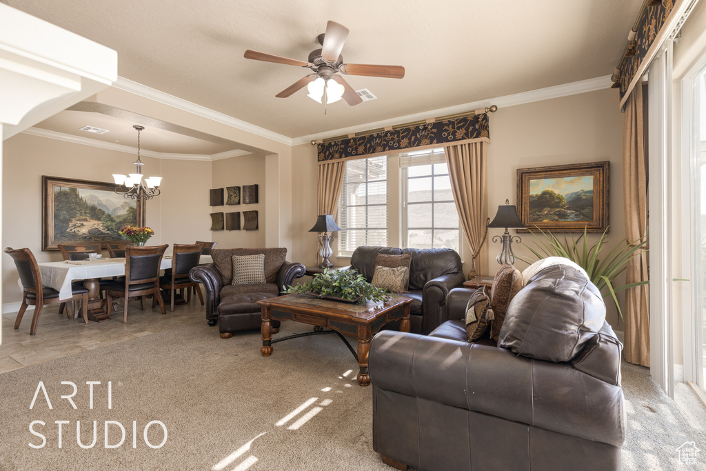 Carpeted living room with ceiling fan with notable chandelier and ornamental molding