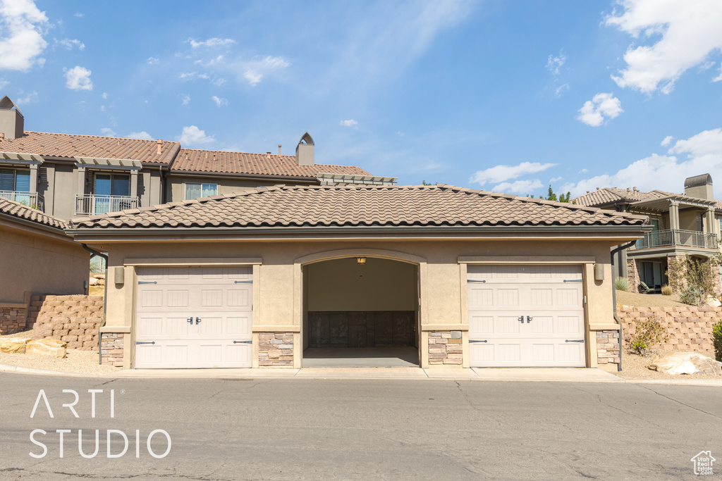 View of front facade featuring a balcony and a garage