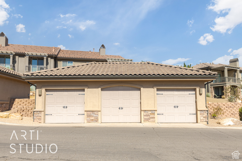 View of front of property with a balcony and a garage