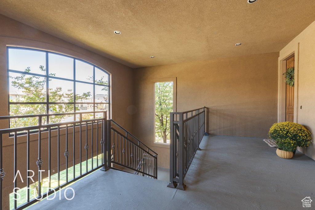 Stairs featuring a textured ceiling and a healthy amount of sunlight