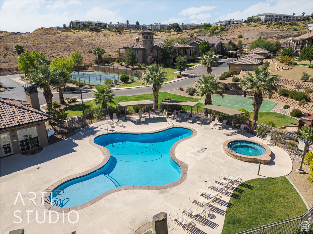 View of pool with a hot tub and a patio area