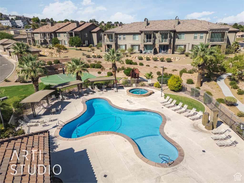 View of swimming pool featuring a community hot tub and a patio area