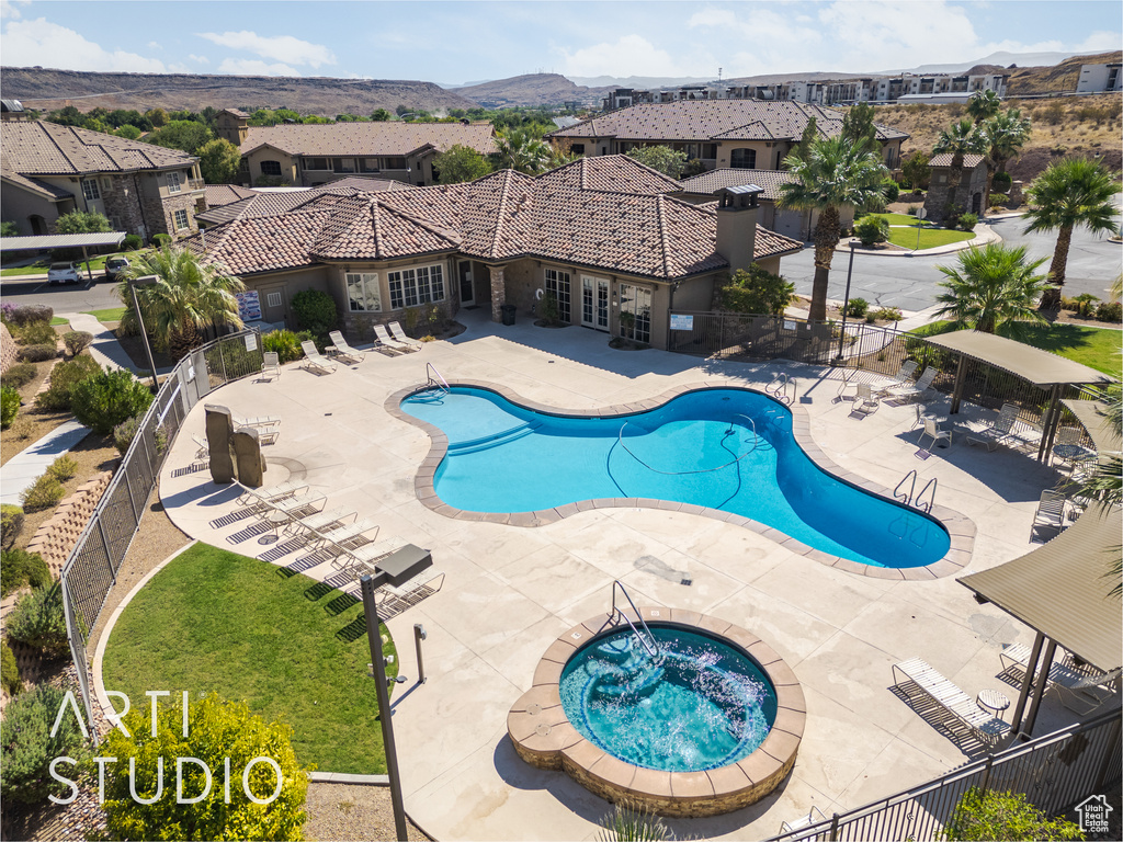 View of swimming pool featuring a patio, a community hot tub, and a mountain view