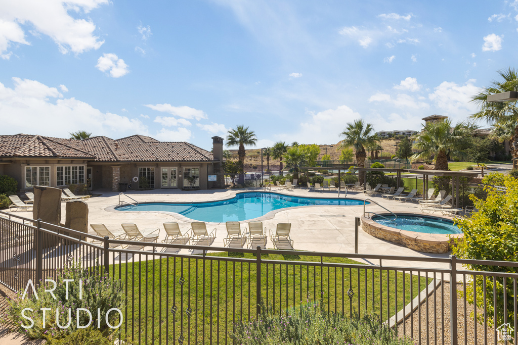 View of swimming pool featuring a yard, a community hot tub, and a patio area