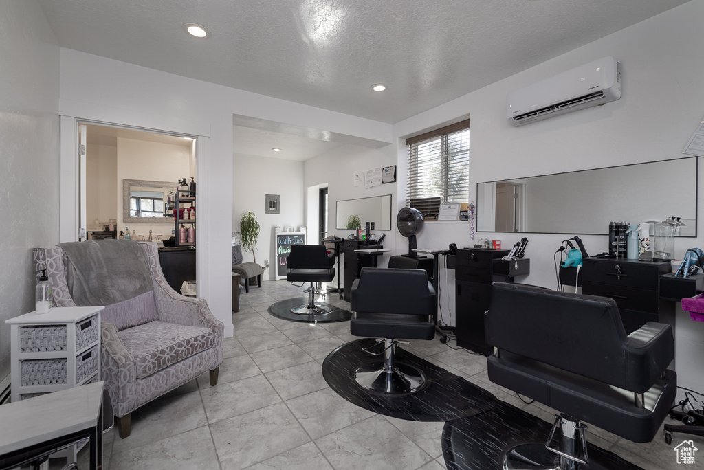 Interior space featuring a textured ceiling and a wall unit AC