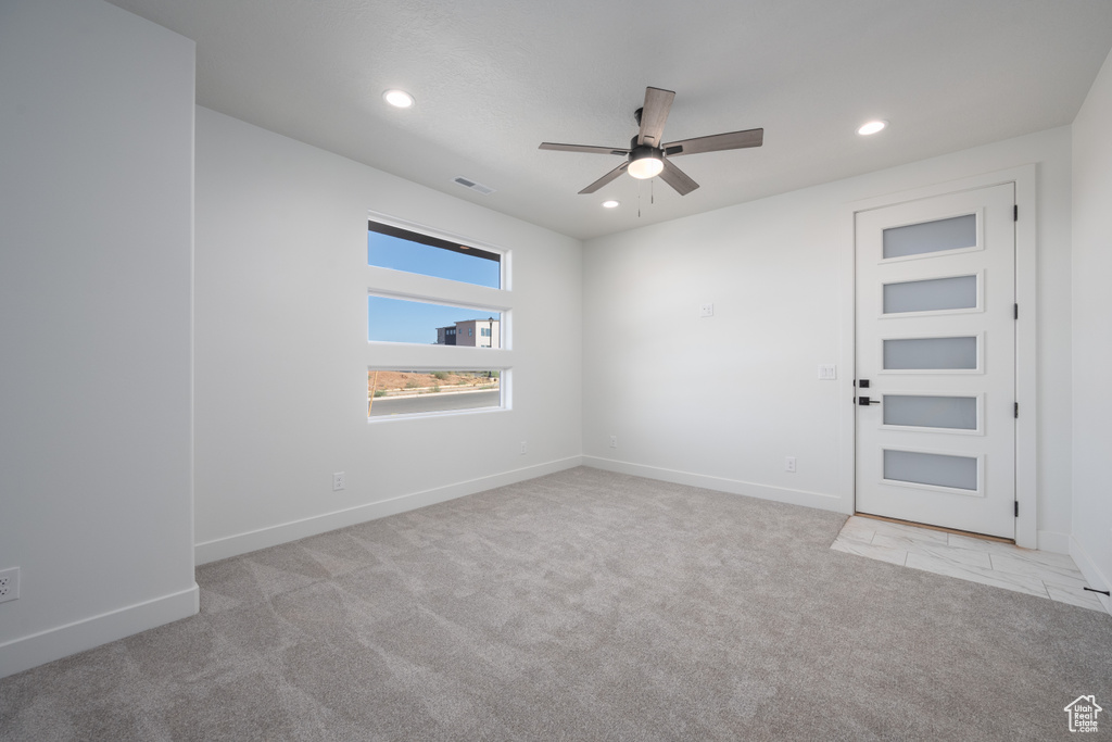 Unfurnished room with ceiling fan and light colored carpet