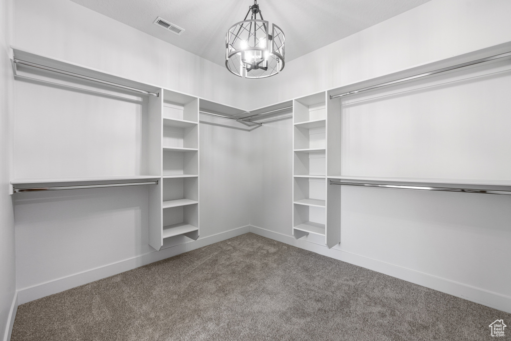 Walk in closet featuring carpet floors and an inviting chandelier