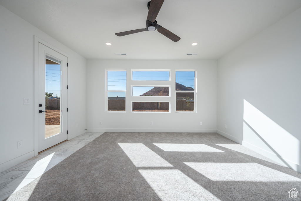 Spare room with ceiling fan and light carpet