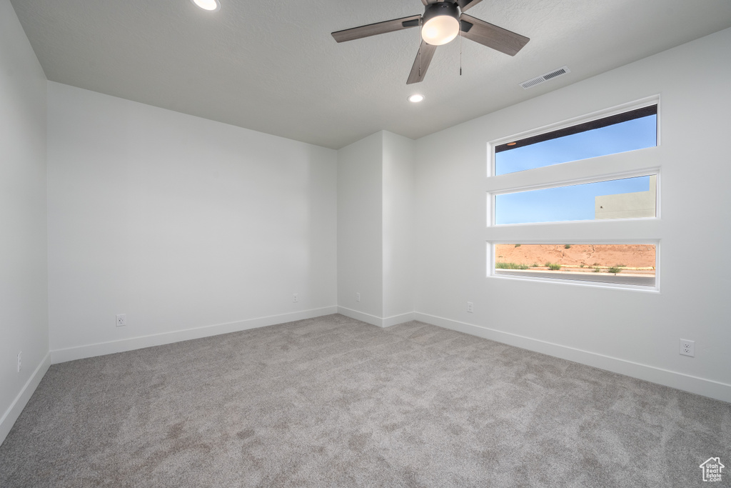 Carpeted spare room with ceiling fan