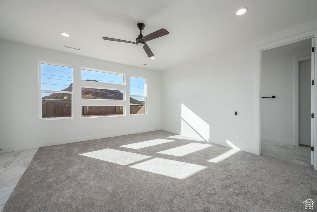 Empty room with light carpet and ceiling fan