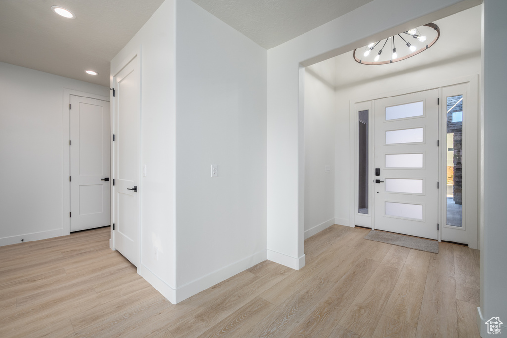 Entryway featuring light wood-type flooring and a chandelier