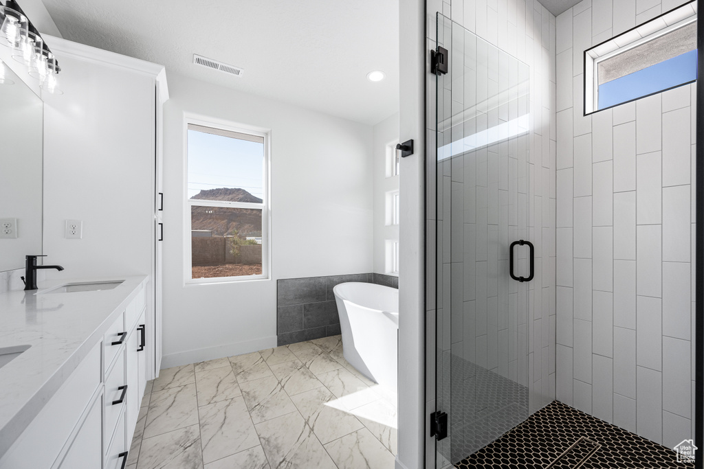 Bathroom featuring vanity and plus walk in shower