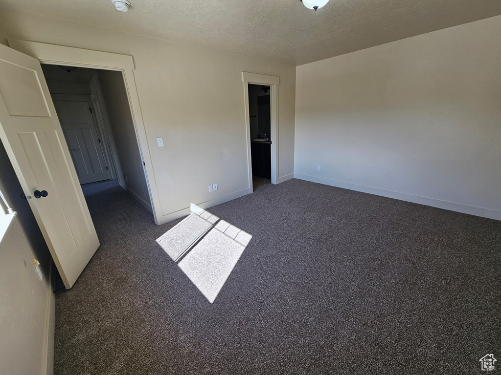 Carpeted spare room featuring a textured ceiling