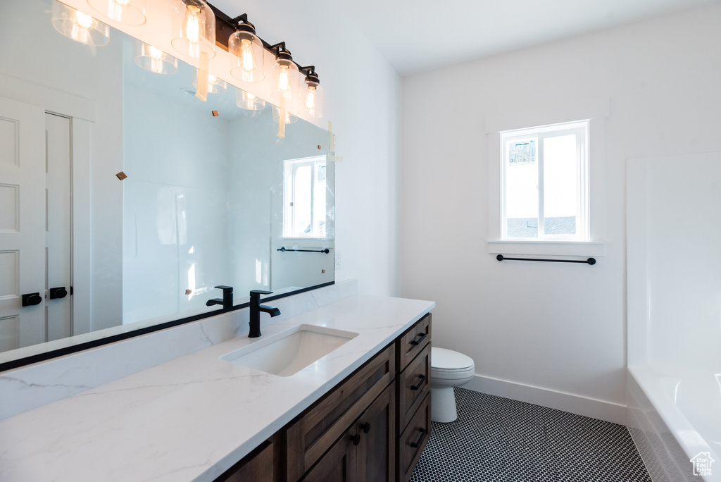 Full bathroom with vanity, plus walk in shower, tile patterned flooring, and toilet