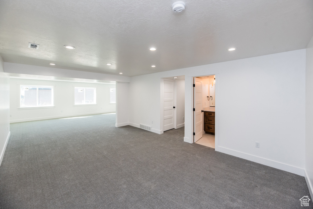 Carpeted empty room with a textured ceiling