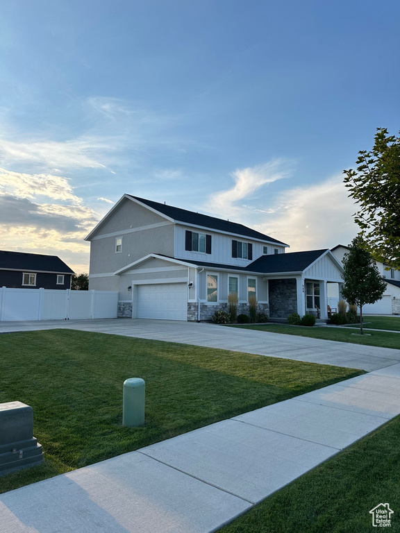 View of front of home with a garage and a front lawn