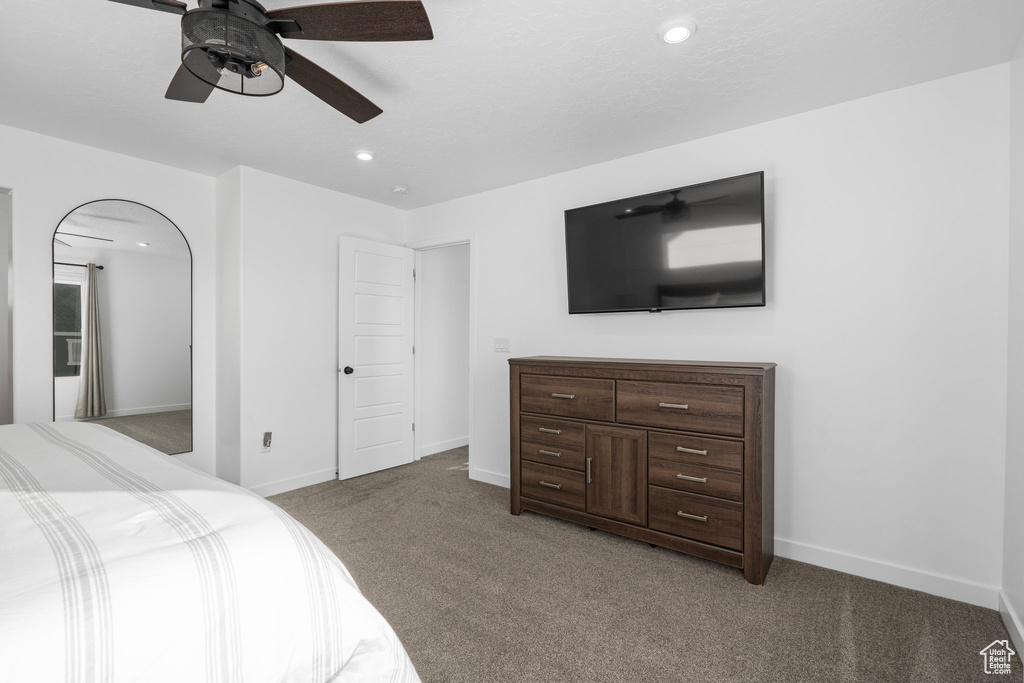 Bedroom with ceiling fan and light carpet