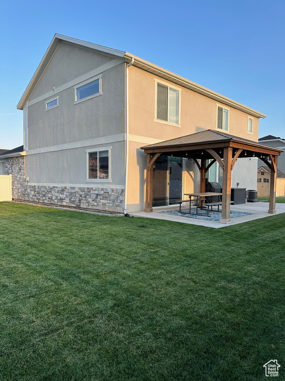 Back of house featuring a gazebo, a lawn, a patio area, and central AC