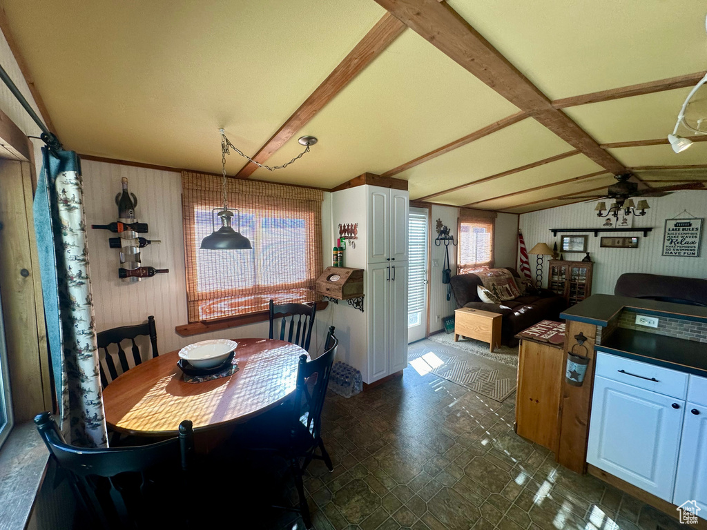 Dining space with vaulted ceiling with beams and ceiling fan