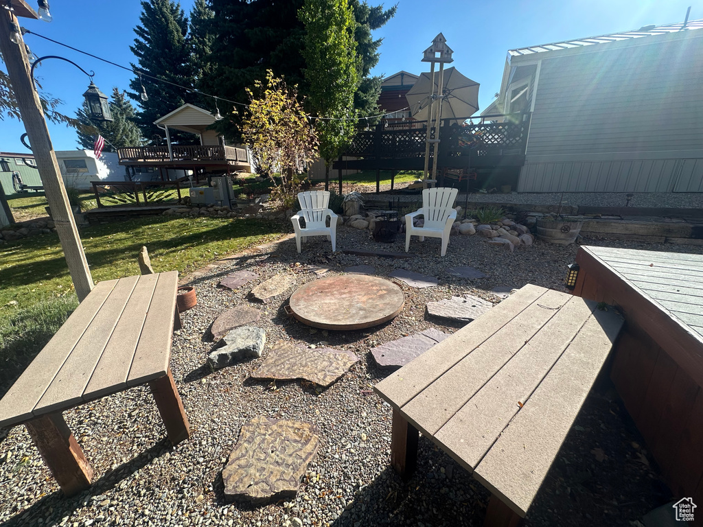 View of patio / terrace featuring a wooden deck and an outdoor fire pit