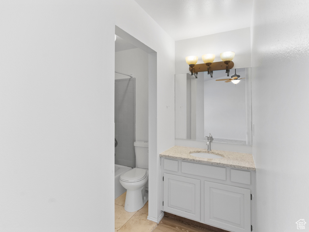 Full bathroom featuring ceiling fan, vanity, shower / bath combination, and toilet