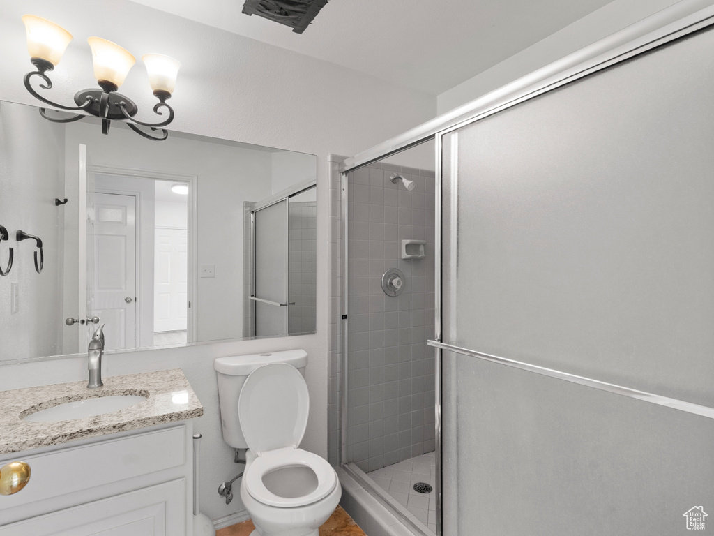 Bathroom with vanity, toilet, and an enclosed shower