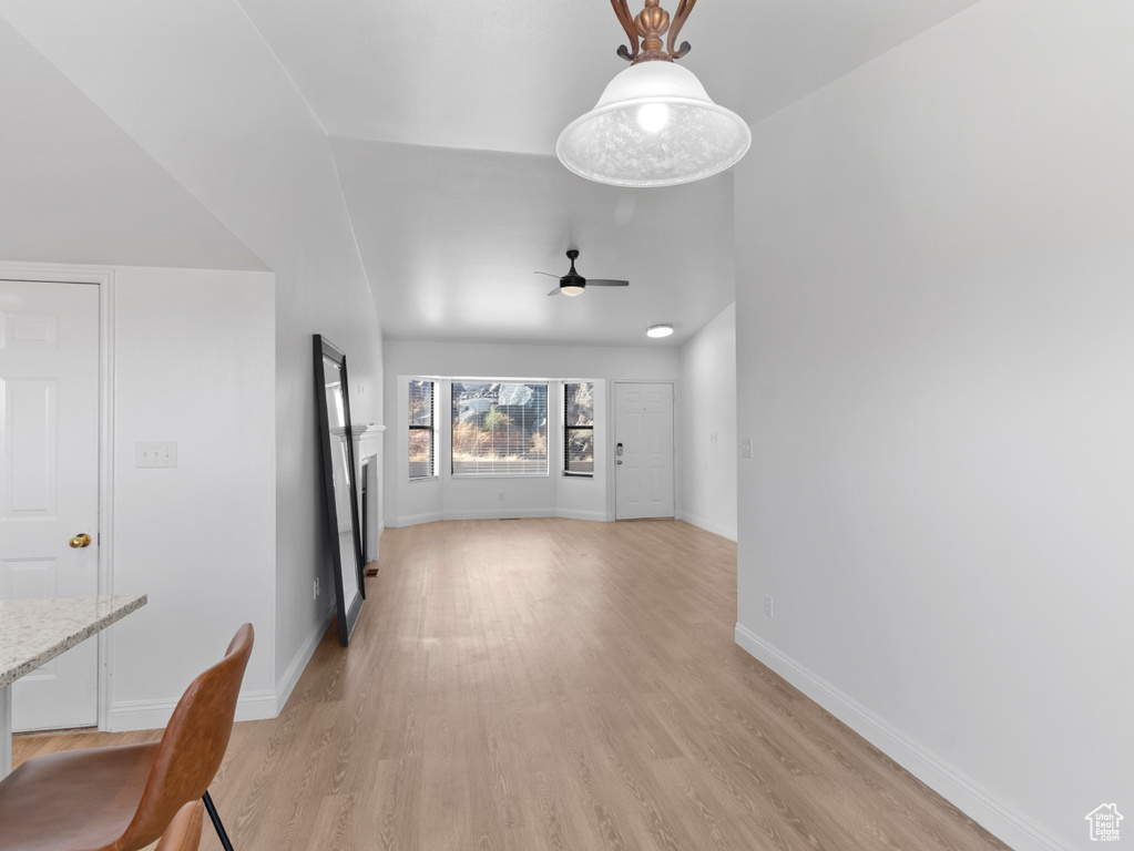 Unfurnished living room featuring ceiling fan, lofted ceiling, and light hardwood / wood-style floors