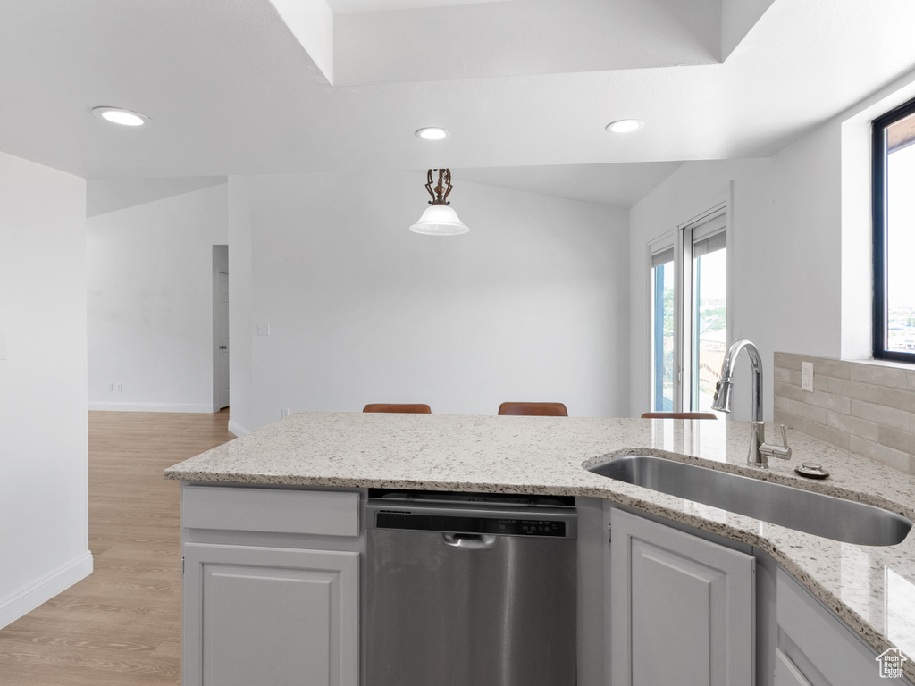 Kitchen featuring light hardwood / wood-style floors, dishwasher, sink, and plenty of natural light