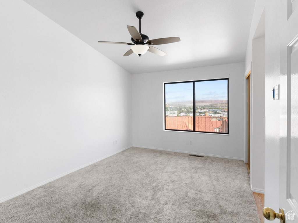 Unfurnished room with ceiling fan and light carpet