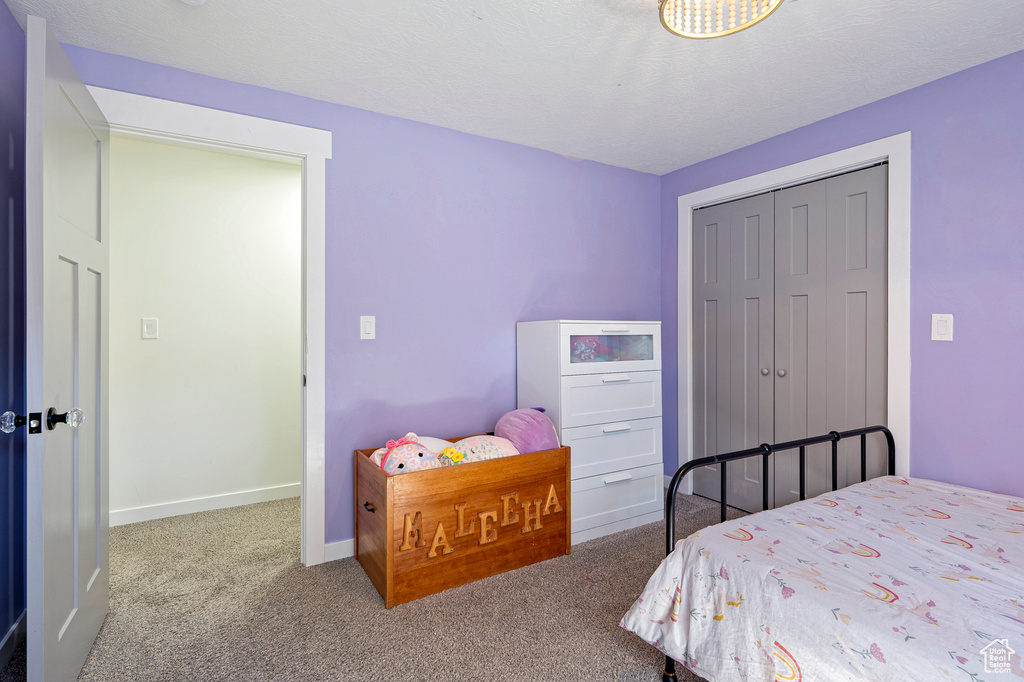 Carpeted bedroom with a closet